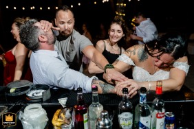 Playa del Carmen, Mexico, is the lively location where several guests' hands fight dramatically to grab the last piece of fresh lime on a busy bar counter.